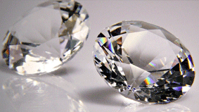 Two large diamond cut diamonds sitting on top of a table.